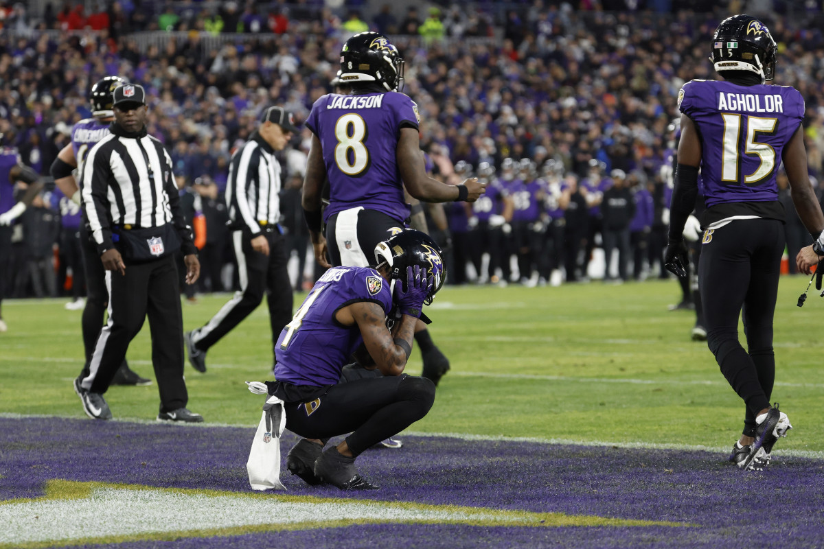 Zay Flowers crouches with his head in his hands in the endzone